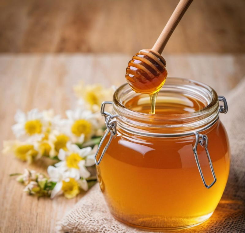 Spoon pouring raw honey into a cup of tea