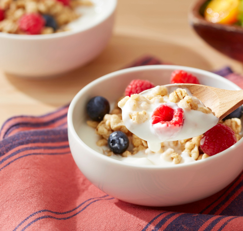 Glass bottle of fresh organic milk on a wooden table with natural lighting