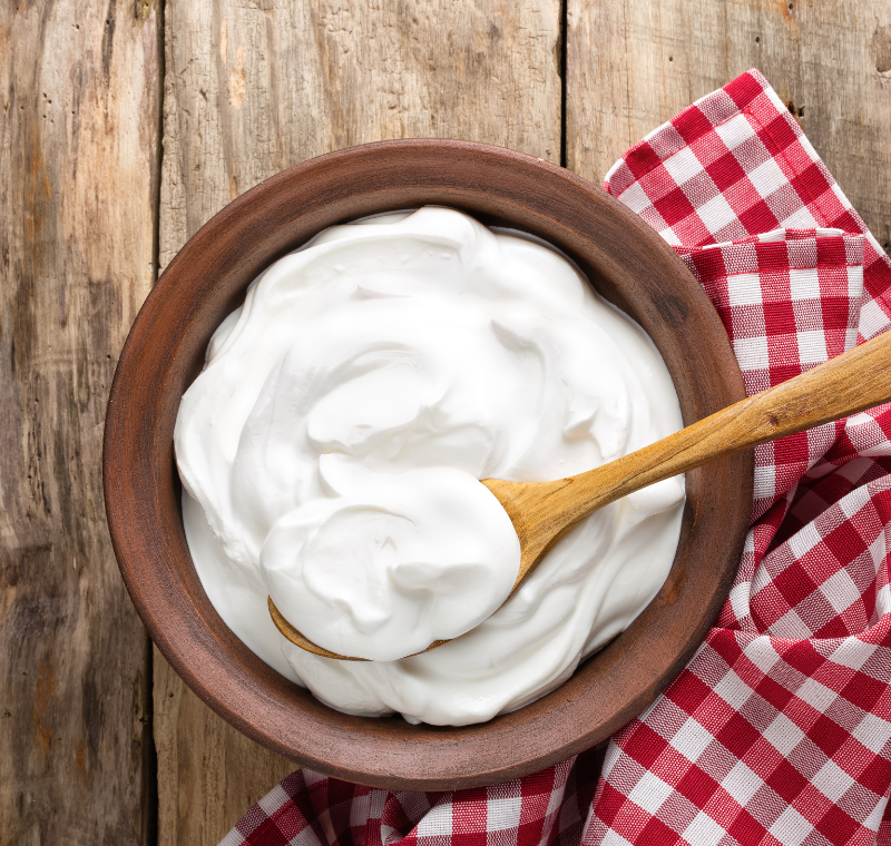 Assorted organic dairy products including milk, yogurt, and butter arranged on table